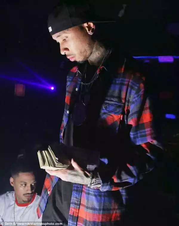 Tyga tosses cash to fans in Miami nightclub (Photos)